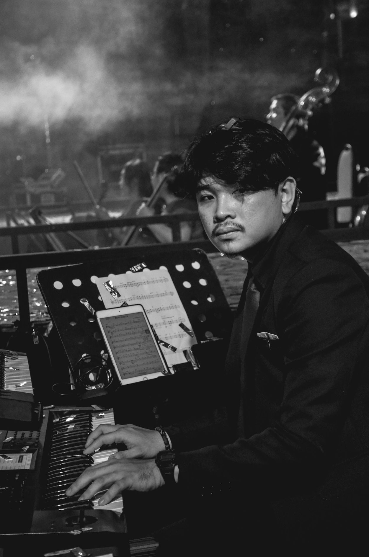 Musiker schaut in die Kamera und sitzt vor seinem Keyboard kurz vor dem Konzert